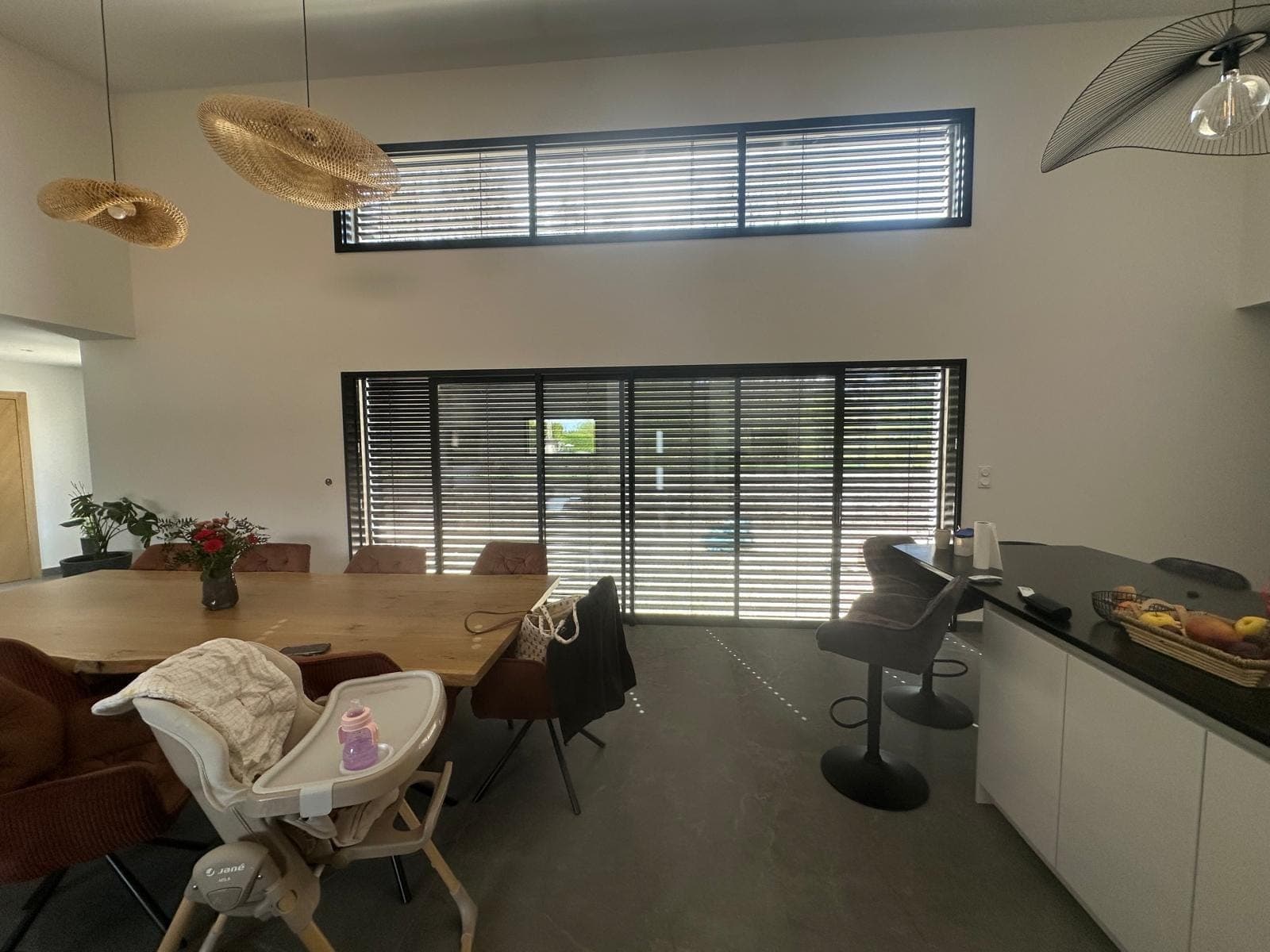 Séjour lumineux avec grandes baies vitrées et brise-soleil orientables posés par REM Fermetures à Belfort